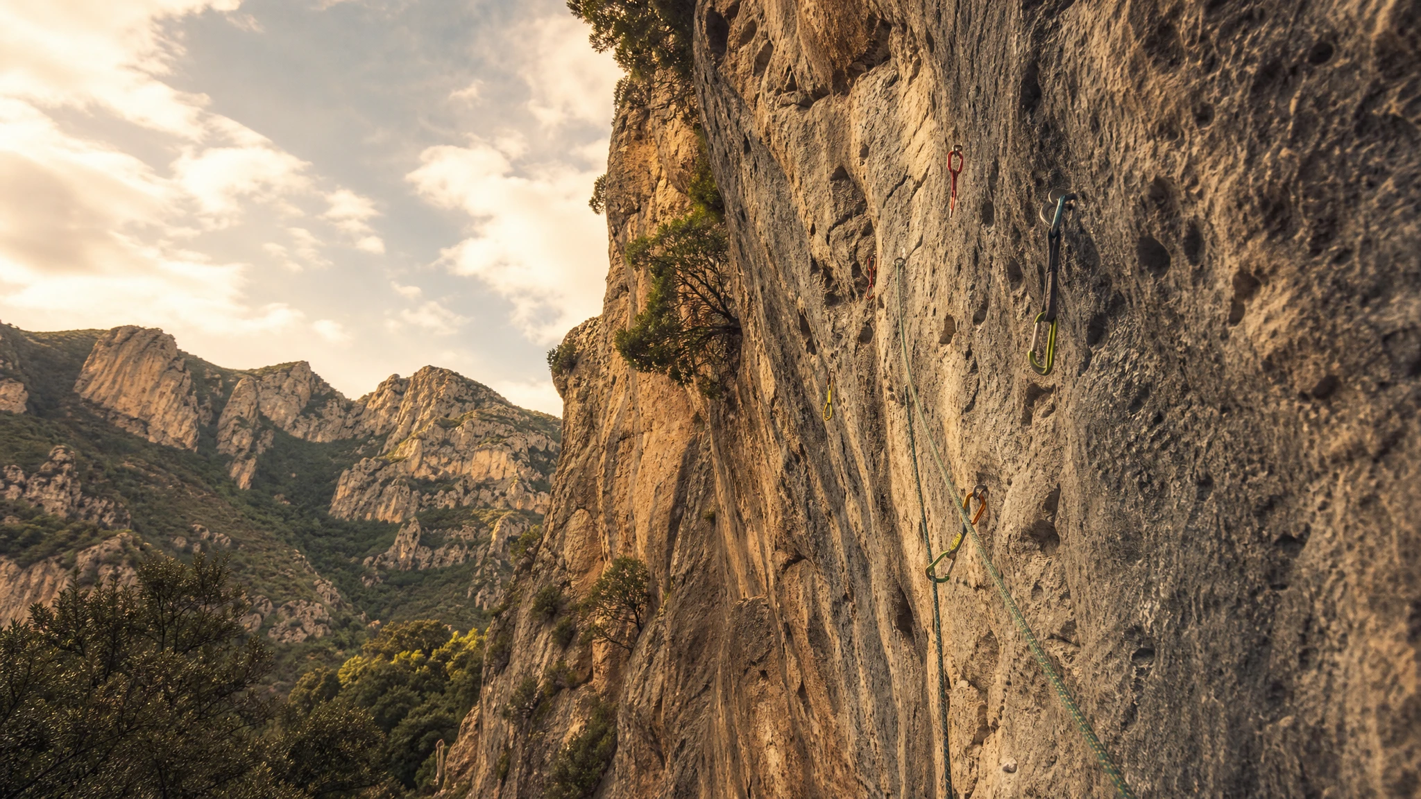 Ilustración de pared de escalada con vías equipadas en paisaje montañoso español
